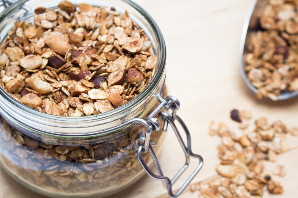 Granola in a jar with a ladle on the side.