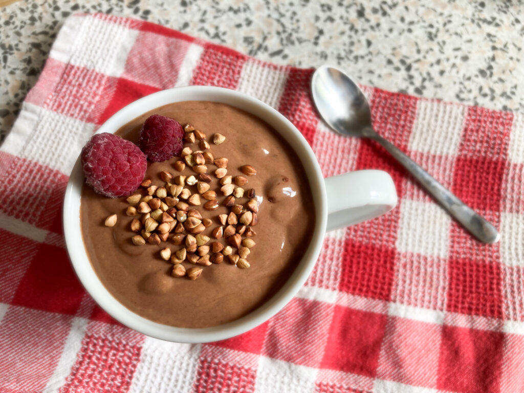 No-choc chocolate smoothie topped with roasted buckwheat and fresh raspberries